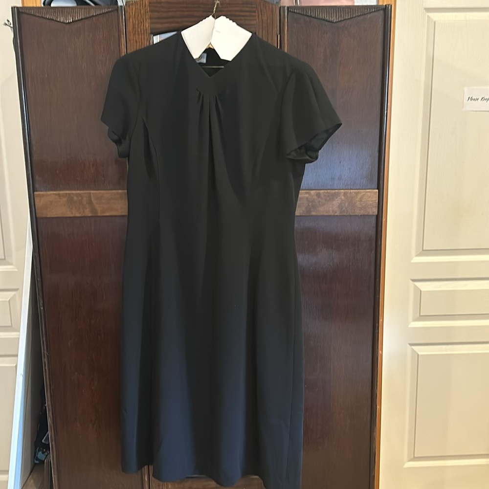 Dressy black just below knee length lined short sleeve dress.